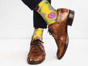 Yellow crew socks with a chrysanthemum floral design, highlighting the texture.
